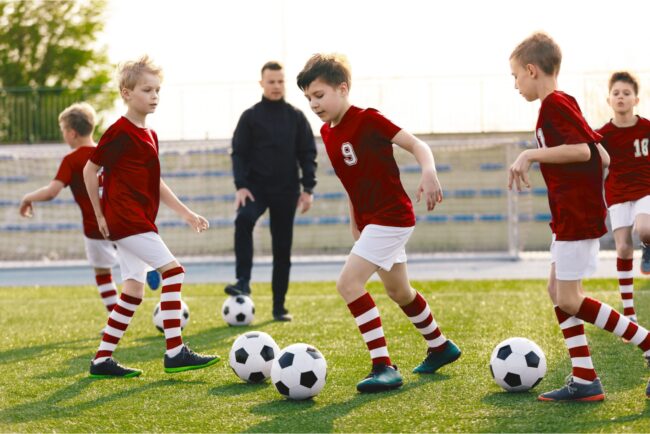 A children’s football coach watching a training session.