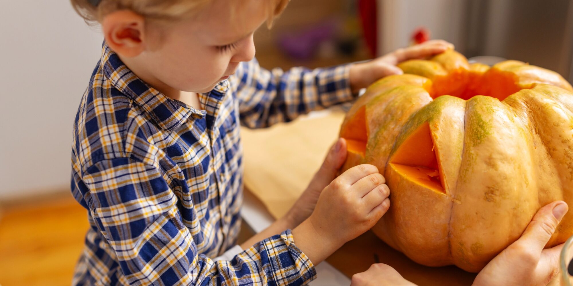 7 – 2025-10-23T113457.377 A child carving a pumpkin.