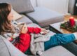 A woman relaxing wearing a Christmas jumper.