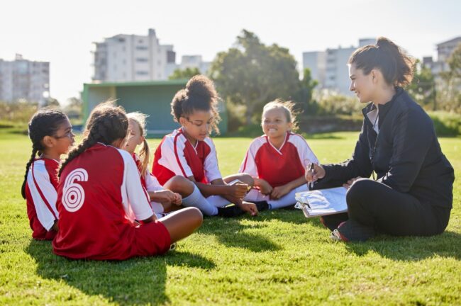 A woman coaching a girl’s football team.