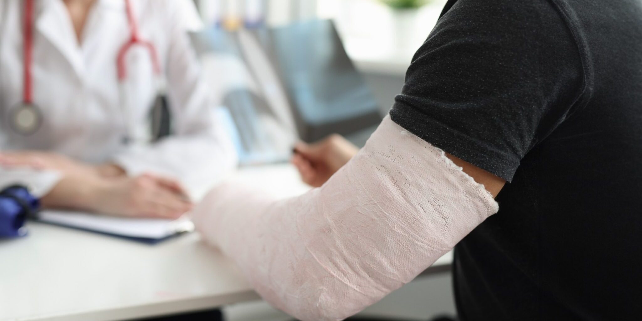 A man with a broken arm speaking with a doctor.