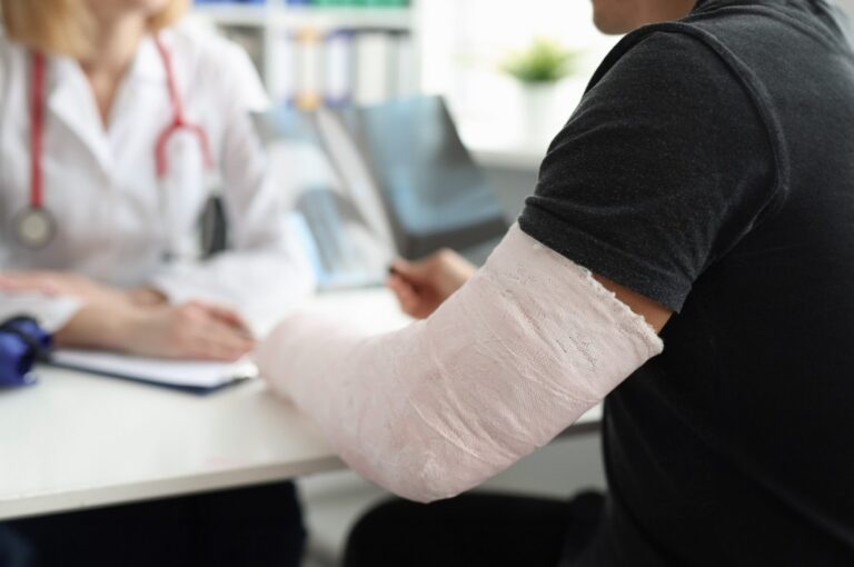 A man with a broken arm speaking with a doctor.