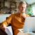 A man in his 50s thinking while using a laptop